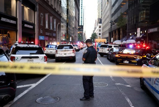 Polisi berjaga usai terjadi baku tembak di gedung pencakar langit, di 345 Park Avenue, Senin (28/7). Foto: CHARLY TRIBALLEAU / AFP