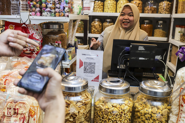 Warga melakukan transaksi QRIS di salah satu kios di Pasar Santa, Jakarta, Selasa (22/7/2025). Foto: Darryl Ramadhan/kumparan