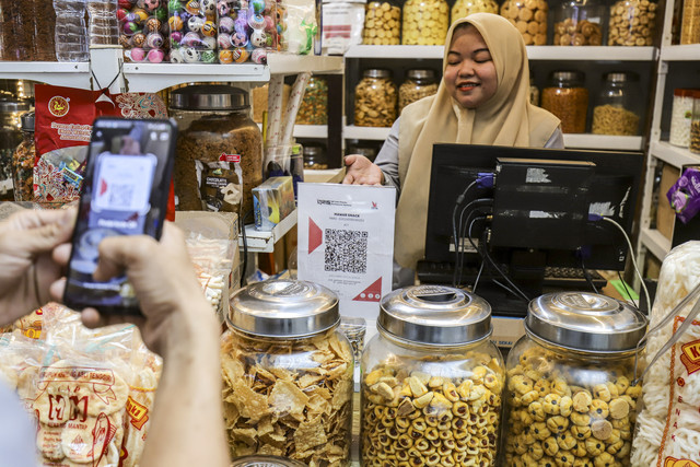 Warga melakukan transaksi QRIS di salah satu kios di Pasar Santa, Jakarta, Selasa (22/7/2025). Foto: Darryl Ramadhan/kumparan