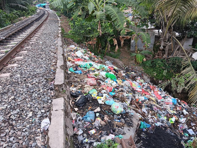Tumpukan sampah di sekitar perlintasan rel kereta api. | Foto: Dok Humas KAI Divre IV Tanjung Karang