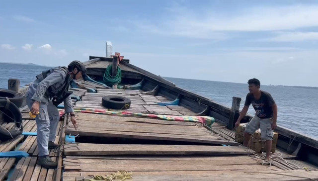 Petugas Bakamla dari KN Tanjung Datu mengecek kapal KM Sinar Bahtera, yang diduga menyelendupkan 400 karung bawang merah di Perairan Kepri, Sabtu (2/8). Foto: Dok. Bakamla