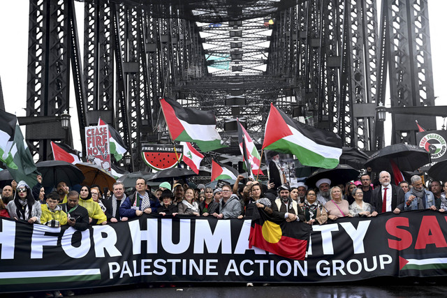 Para demonstran berbaris melintasi Jembatan Pelabuhan Sydney dalam demonstrasi pro-Palestina yang menentang tindakan Israel dan kekurangan pangan yang sedang berlangsung di Jalur Gaza, di Sydney, Minggu (3/8/2025). Foto: Saeed Khan/AFP