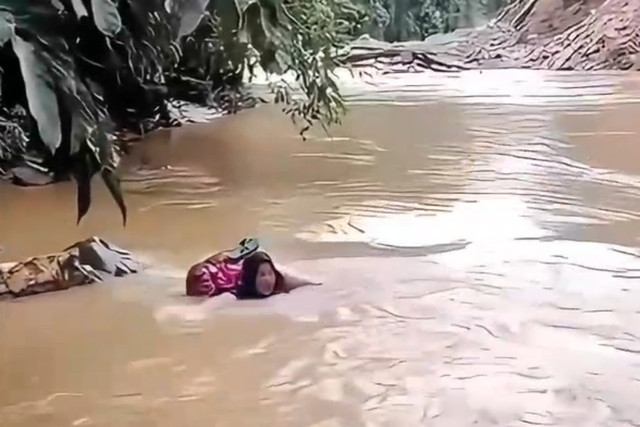 Bidan Dona bertaruh nyawa seberangi sungai untuk membantu warga di Pasaman. Foto: Dok. Istimewa