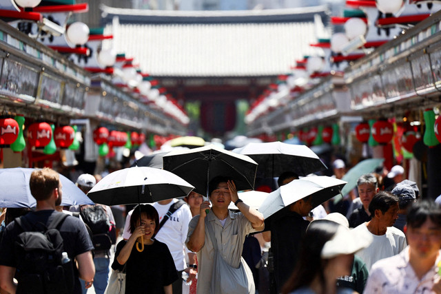 Warga menggunakan payung berjalan di tengah gelombang panas yang melanda wilayah Tokyo, Jepang, Selasa (5/8/2025). Foto: Issei Kato/REUTERS