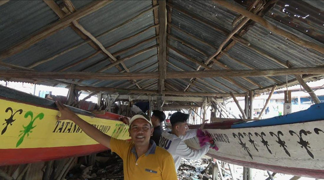 Perajin Perahu Bidar di Kota Palembang saat membersihkan perahu bidar yang akan ikut lomba perahu bidar akan digelar pada 15–17 Agustus 2025 mendatang di Sungai Musi. Foto : Abdullah Toriq/Urban Id