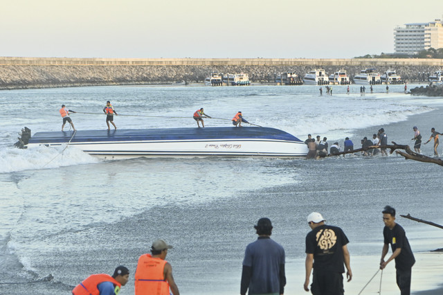 Warga berusaha menarik kapal cepat Bali Dolphin Cruise 2 ke tepi pantai di kawasan Sanur, Denpasar, Bali, Selasa (5/8/2025). Foto: Fikri Yusuf/ANTARA FOTO