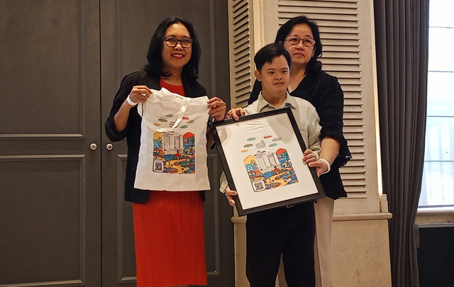 Edo, penyandang down syndrome di Surabaya menunjukkan lukisannya yang dijadikan sovenir hotel dalam bentuk shopping bag. Foto: Masruroh/Basra