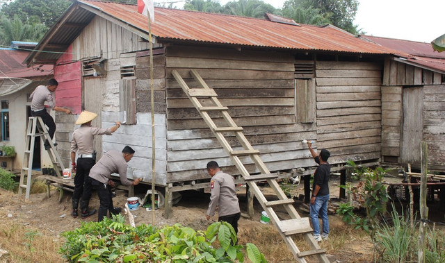 Polisi mengecat rumah warga di Ensalang, Kabupaten Sekadau. Foto: Dok. Polres Sekadau