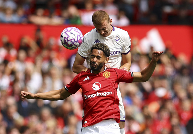 Pietro Comuzzo dari Fiorentina beraksi bersama Matheus Cunha dari Manchester United pada pertandingan persahabatan antara Manchester United vs Fiorentina di Old Trafford, Manchester, Britania Raya, Minggu (10/8/2025) dini hari WIB. Foto: Andrew Boyers/REUTERS