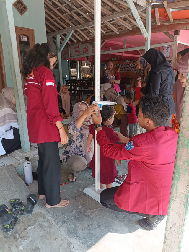 Anggota KKM 71 membantu cek kesehatan di rumah bu lurah desa binong.