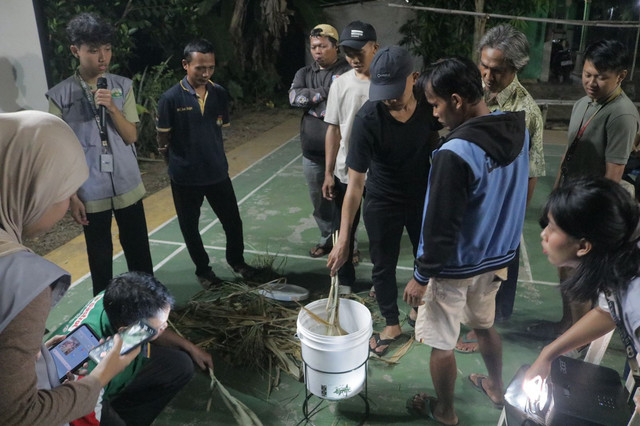 Mahasiswa KKN GIAT 12 UNNES mendampingi peternak Desa Kutorejo mencoba mesin pencacah rumput low budget.