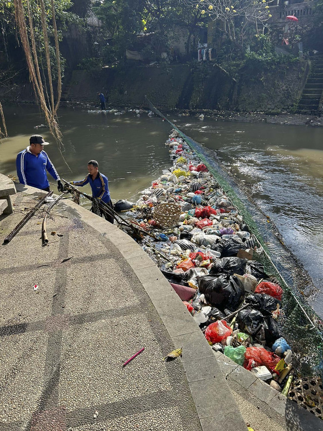 Petugas mengangkut sampah yang dibuang sembarangan ke sungai di Kota Denpasar, Rabu (12/8/2025). Foto: Dinas PUPR Kota Denpasar 
