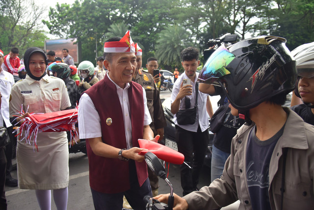Wali Kota Palembang, Ratu Dewa saat membagikan bendera merah putih ke warga Kota Palembang/ist. 