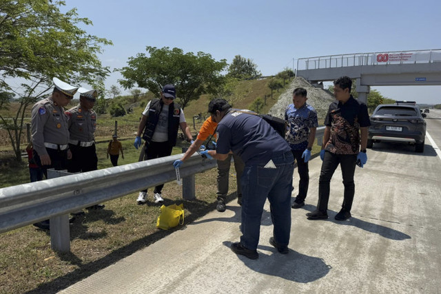 Polisi memeriksa tote bag berisi ratusan peluru di Tol Ngawi-Kertosono, Jumat (15/8/2025). Foto: Dok. Istimewa