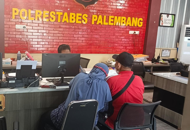 Orang tua korban saat melaporkan dugaan teror terhadap anaknya di SPKT Polrestabes Palembang. Foto : Istimewa