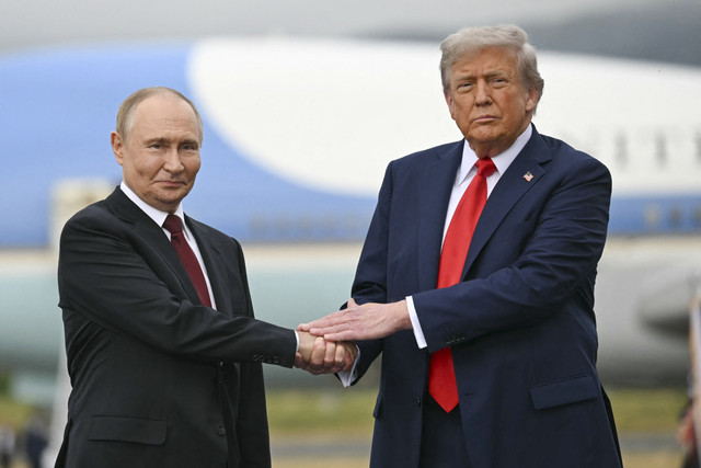 Presiden Amerika Serikat Donald Trump berjabat tangan dengan Presiden Rusia Vladimir Putin setibanya untuk melakukan pertemuan terkait KTT AS-Rusia di Pangkalan Gabungan Elmendorf-Richardson, Anchorage, Alaska, Jumat (15/8/2025). Foto: Andrew Caballero-Reynolds/AFP