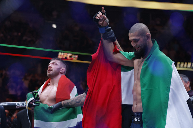 Khamzat Chimaev (sarung tangan biru) bereaksi setelah pertarungan melawan Dricus Du Plessis Murphy (sarung tangan merah) selama UFC 319 di United Center. Foto: Kamil Krzaczynski-Imagn Images/Via Reuters
