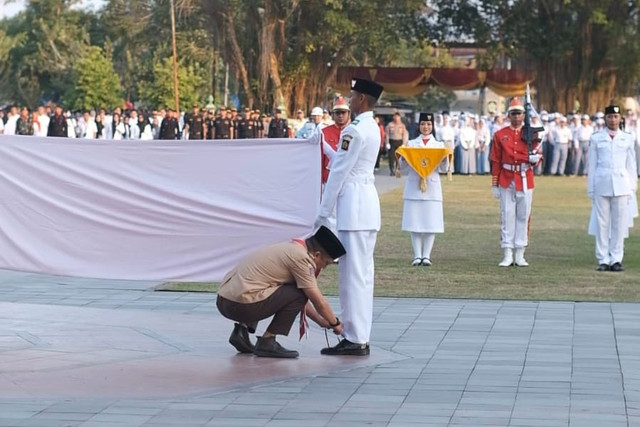 Momen Wakil Bupati Kulon Progo, Ambar Purwoko mengikat tali sepatu Paskibraka yang lepas saat upacara penurunan bendera Merah Putih di Alun-alun Kabupaten Kulon Progo, Minggu (17/8/2025). Foto: Dok. Ambar Purwoko