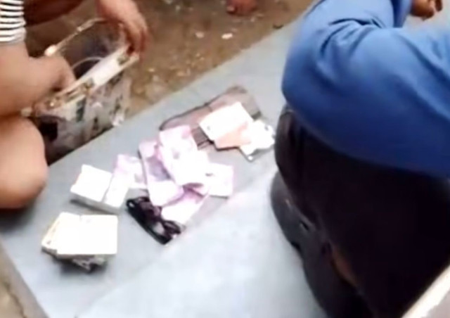 Seorang warga membongkar tas pria tersebut dan mengeluarkan uang palsu yang dibawa pria tersebut. Foto: Istimewa