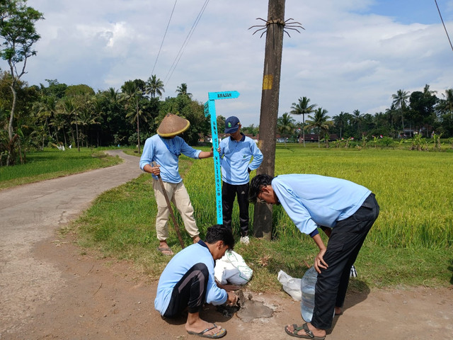 proses pemasangan plang petunjuk jalan di desa krandon lor.