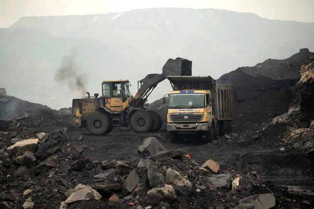 Seorang pekerja mengoperasikan wheel loader untuk menurunkan tumpukan batu bara mentah ke dalam truk yang digali dari tambang terbuka di pinggiran Dhanbad, negara bagian Jharkhand, India, pada 13 Agustus 2025. Foto: Vishal kumar singh / AFP