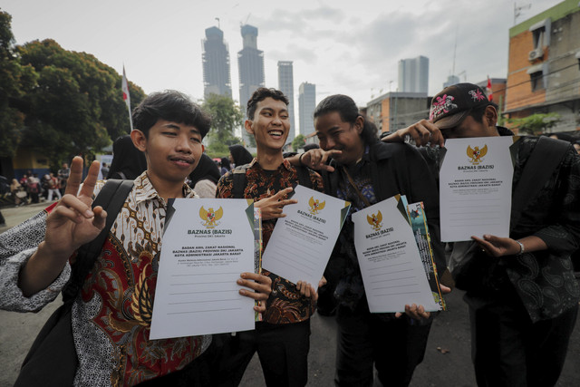 Sejumlah siswa berpose menunjukkan dokumen ijazah saat program pemutihan penundaan pemberian ijazah di SMA Islam Said Naum, Tanah Abang, Jakarta, Kamis, (21/8/2025). Foto: Jamal Ramadhan/kumparan