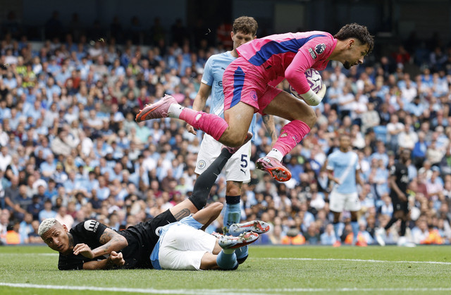 Kiper Manchester City James Trafford berhasil menangkap bola setelah berebut bola dengan pemain Tottenham Hotspur Richarlison dalam pertandingan Liga Inggris di Stadion Etihad, Manchester, Inggris, Sabtu (23/8/2025). Foto: Jason Cairnduff/Reuters