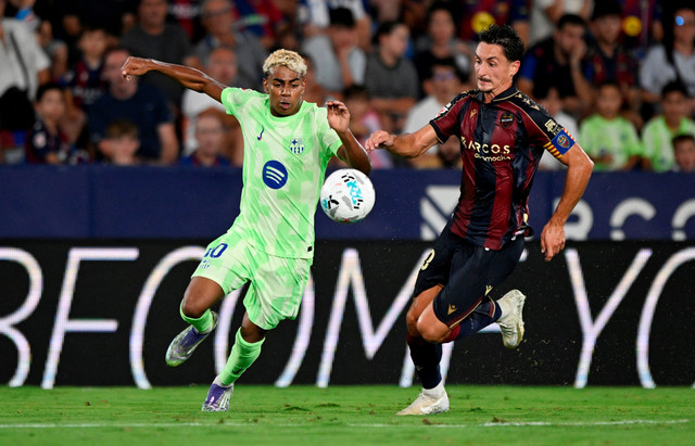 Duel Lamine Yamal dengan Pablo Martinez saat Levante vs Barcelona dalam laga pekan pertama Liga Spanyol 2025/26 di Stadion Ciutat de Valencia, Minggu (24/8) dini hari WIB. Foto: REUTERS/Pablo Morano