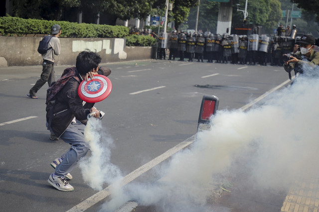 Salah satu massa aksi melemparkan kembali gas air mata ke arah aparat saat demo di belakang DPR hingga kawasan stasiun Palmerah, Jakarta, Senin (25/8/2025). Foto: Jamal Ramadhan/kumparan