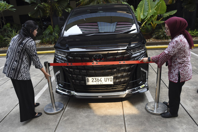Karyawan KPK memasang batas pengaman di mobil Alphard yang disita sebagai barang bukti kasus dugaan pemerasan pengurusan sertifikat K3 di Kementerian Ketenagakerjaan, di Gedung Merah Putih KPK, Jakarta, Selasa (26/8/2025). Foto: Indrianto Eko Suwarso/ANTARA FOTO
