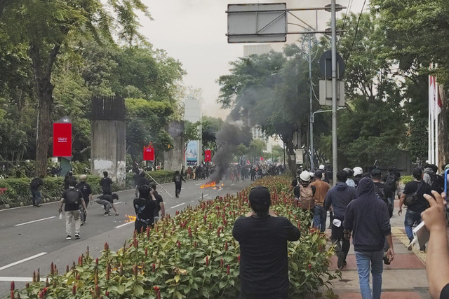 Massa aksi unjuk rasa melempari bom molotov kepada polisi berbaju sipil saat demonstrasi di kawasan Senayan, Jakarta, Kamis (28/8/2025). Foto: Luthfi Humam/kumparan