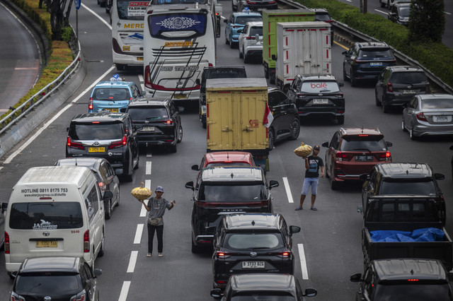 Dua pedagang menjajakan dagangannya saat terjadi kemacetan di Jalan Tol Dalam Kota, Jakarta, Kamis (28/8/2025). Foto: Bayu Pratama S/ANTARA FOTO