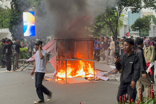 Massa pendemo membakar spanduk di Jalan Asia Afrika, Jakarta, Kamis (28/8/2025). Foto: Abid Raihan/kumparan