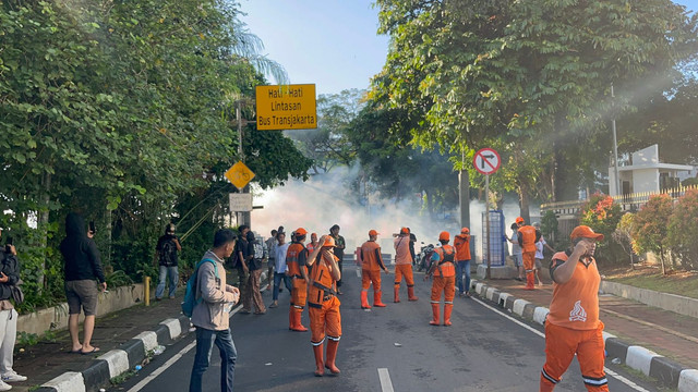 Pasukan oranye menghindari gas air mata yang ditembakkan pasukan Brimob saat ricuh di depan Mako Brimob Polda Metro Jaya, Jakarta, Jumat (29/8/2025). Foto: Rayyan Farhansyah/kumparan