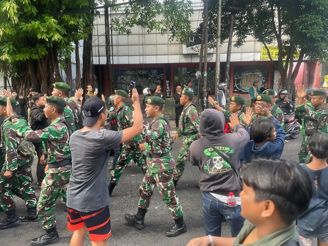 Massa aksi menyapa para TNI yang hadir saat demo di kawasan Mako Brimob Kwitang, Jakarta, Jumat (28/9/2025). Foto: Darryl Ramadhan/kumparan