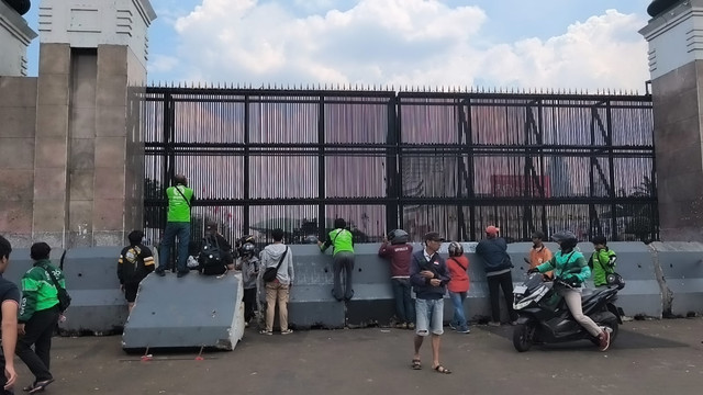 Sekelompok ojol meluapkan kekesalan dengan melempar sampah ke dalam gerbang DPR di Jalan Gatsu, Jakarta, Jumat (29/8/2025). Foto: Thomas Bosco/kumparan