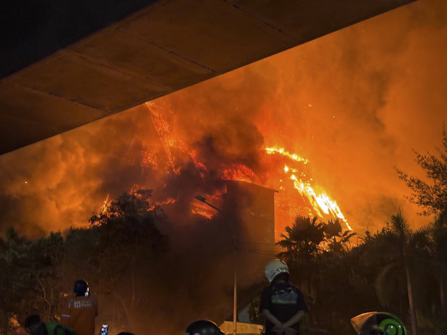 Gedung DPRD Makassar terbakar imbas rembetan api dari motor dan mobil di halaman gedung DPRD Makassar yang dibakar massa pendemo, Jumat (29/8/2025). Foto: kumparan