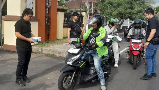 Polisi membagikan makanan kotak untuk para pengemudi ojek online (ojol) yang melintas di depan markas Polda Sulawesi Utara yang ada di Jalan Bethesda Sario, Kota Manado, Sabtu, 30 Agustus 2025.