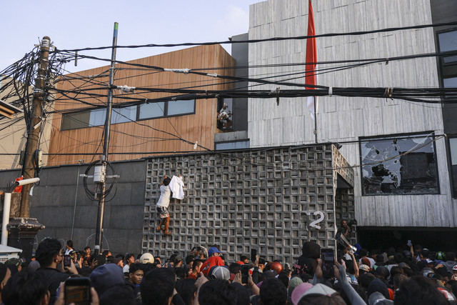 Massa mengeluarkan barang milik anggota DPR Ahmad Sahroni dari dalam rumahnya di kawasan Tanjung Priok, Jakarta, Sabtu (30/8/2025). Foto: Dhemas Reviyanto/ANTARA FOTO