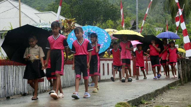 Anak-anak asal Desa Wawonian, Kecamatan Likupang Barat, Kabupaten Minahasa Utara (Minut), Sulawesi Utara (Sulut), berjalan kaki menuju sekolah mereka. (febry kodongan)