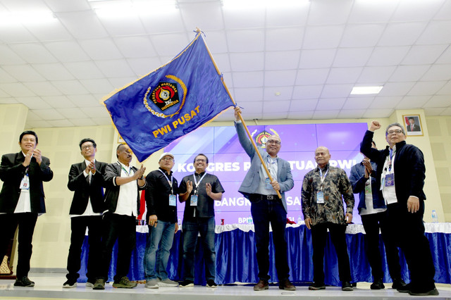 Akhmad Munir (membawa bendera PWI) terpilih menjadi Ketua Umum PWI Pusat. 
 Foto: Dok. Istimewa