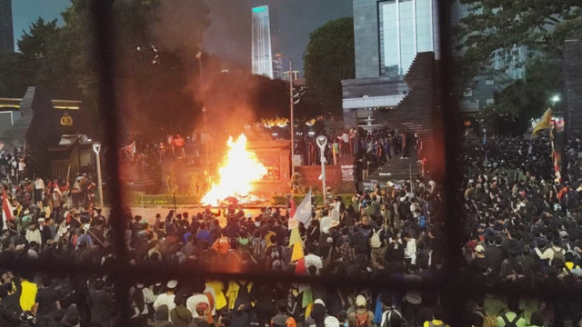 Massa membakar pembatas jalan saat aksi unjuk rasa di depan Polda Metro Jaya, Jakarta, Jumat (29/8/2025).Foto: Jonathan Devin/kumparan
