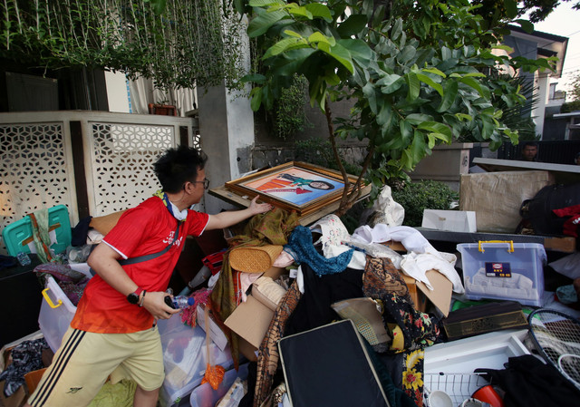 Pekerja mengumpulkan barang yang dikeluarkan dari rumah Menteri Keuangan Sri Mulyani oleh massa tidak dikenal di Bintaro, Tangerang Selatan, Banten, Minggu (31/8/2025). Foto: Muhammad Iqbal/ANTARA FOTO