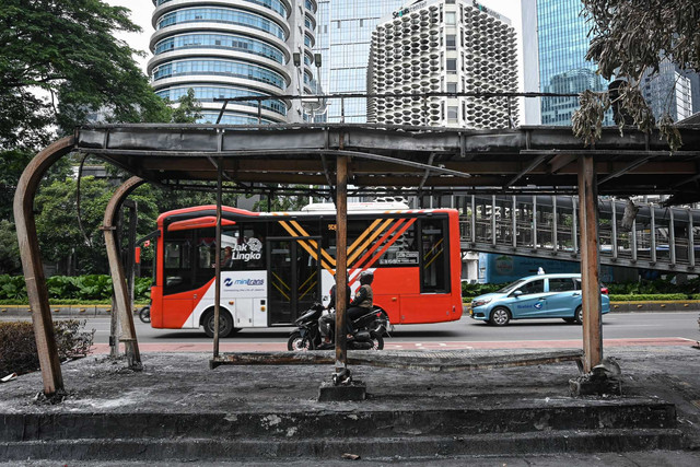 Bus Transjakarta melintas di dekat halte yang hangus terbakar di kawasan Senayan, Jakarta, Minggu (31/8/2025). Foto: Sulthony Hasanuddin/ANTARA FOTO 