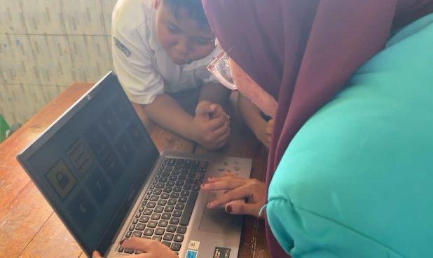 Mahasiswa UMS tunjukan kepada siswa cara kerja aplikasi. (Sumber: Pribadi)