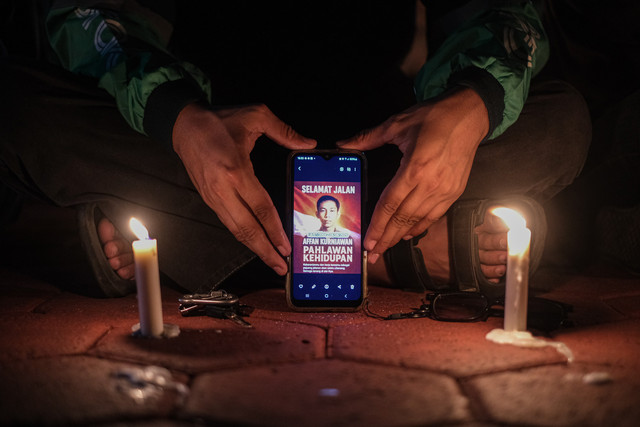 Seorang pengemudi ojek daring menunjukkan foto mendiang Affan Kurniawan saat aksi solidaritas dan doa bersama di Halaman Mapolda Sultra, Kendari, Sulawesi Tenggara, Minggu (31/8/2025). Foto: Andry Denisah/ANTARA FOTO