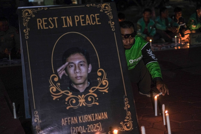 Seorang pengemudi ojek daring membakar lilin saat aksi solidaritas dan doa bersama di Halaman Mapolda Sultra, Kendari, Sulawesi Tenggara, Minggu (31/8/2025). Foto: Andry Denisah/ANTARA FOTO