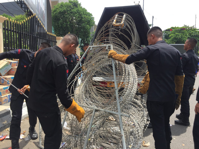 Petugas keamanan memasang barikade kawat berduri mengelilingi Gedung DPRD Sumsel.(foto: Anyelir Ayu)