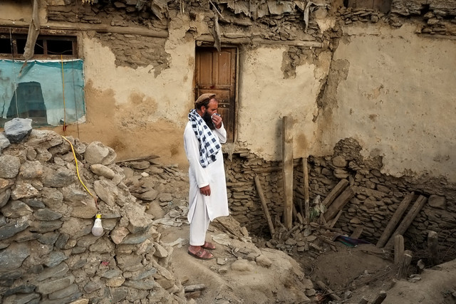Seorang pria berdiri di depan Rumah yang hancur akibat gempa di Desa Mazar Dara, Nurgal, Afghanistan, Senin (1/9/2025). Foto: Sayed Hassib/Reuters