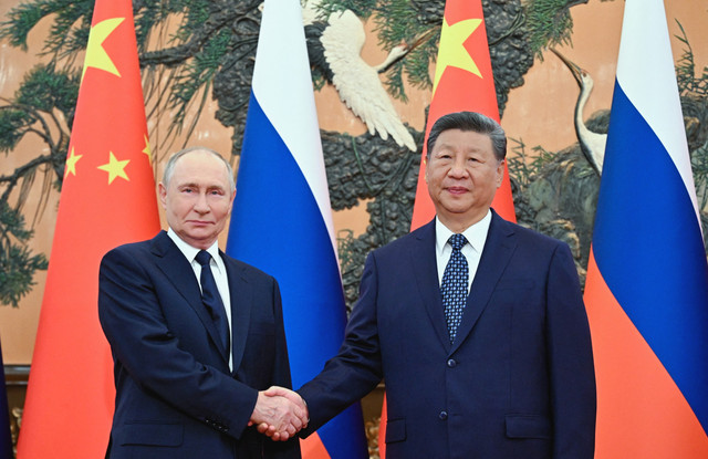 Presiden Rusia Vladimir Putin berjabat tangan dengan Presiden Tiongkok Xi Jinping dalam pertemuan di Balai Agung Rakyat di Beijing, Selasa (2/9/2025). Foto: Sergei Bobylyov / POOL / AFP